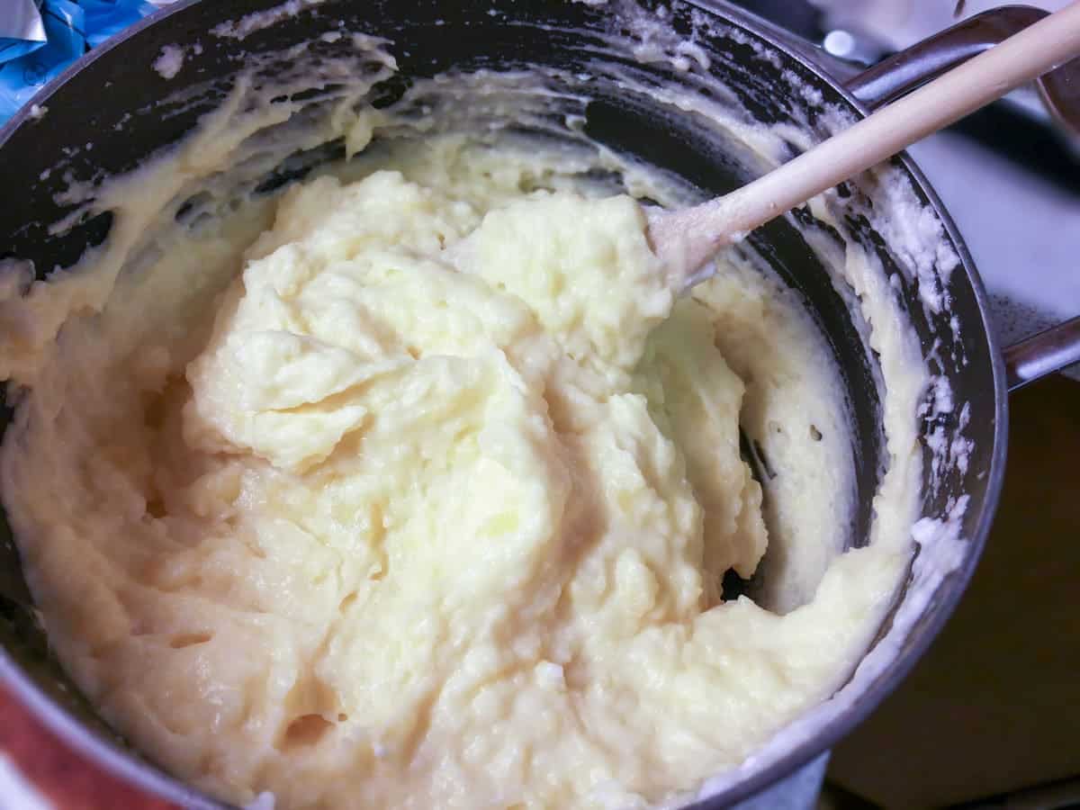 Kartoffelmos røres med en træske i en gryde