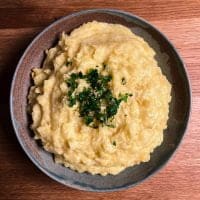 En skål med cremet kartoffelmos toppet med hakket persille